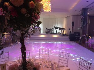 
"Joyful newlyweds and guests dance under twinkling lights on a beautifully decorated wedding dance floor, creating a heart-warming and festive atmosphere."