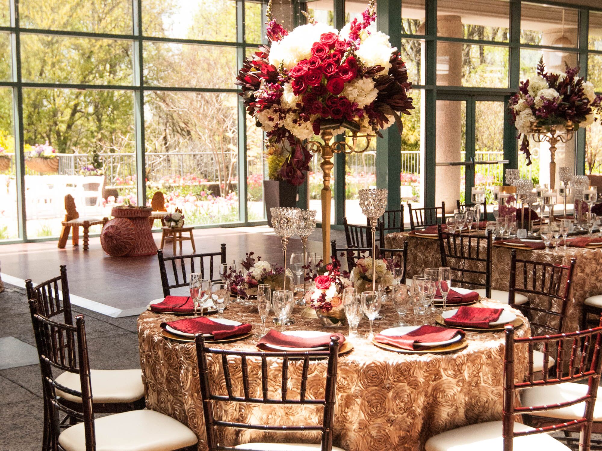Red and ivory centerpiece on gold reception tables